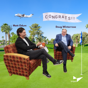 Two men sit in chairs with a golf course in the background and a plane in the sky pulling a banner that says, "Congrats"