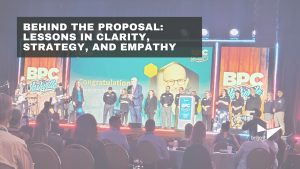 A conference stage with people standing and holding awards, a large screen displaying 'Congratulations on your retirement' with an image of a man, and an audience seated in front. Text overlay reads: 'BEHIND THE PROPOSAL: LESSONS IN CLARITY, STRATEGY, AND EMPATHY.' Logos for BPC Nashville and bn|bright are visible.