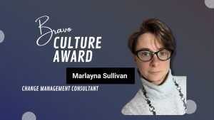 The image is a graphic announcing the Bravo Culture Award. It features a blurred-out photo of Marlayna Sullivan, who is identified as a Change Management Consultant. The background is dark with gradient shades, and there are decorative elements like lines and dots. The text includes 'Bravo CULTURE AWARD,' 'Marlayna Sullivan,' 'CHANGE MANAGEMENT CONSULTANT'